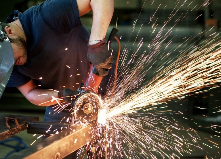 man cutting steel