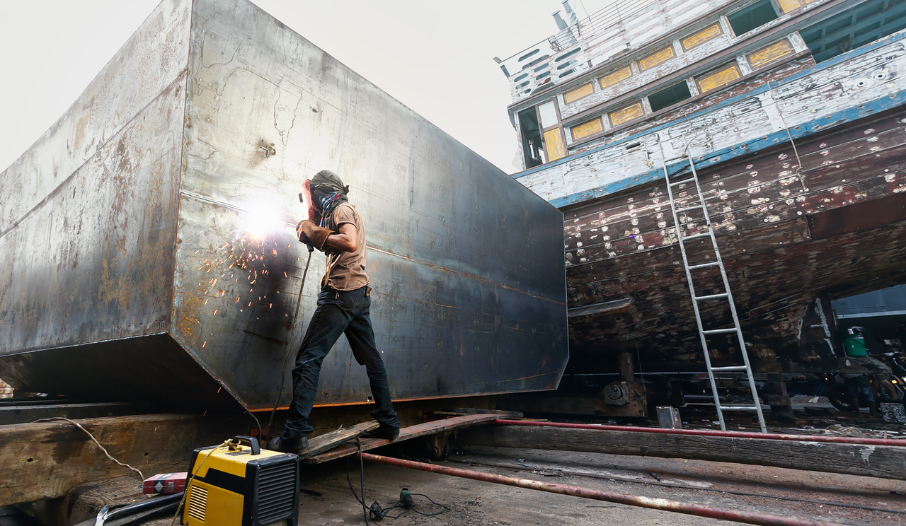 A man welding steel on to a ship