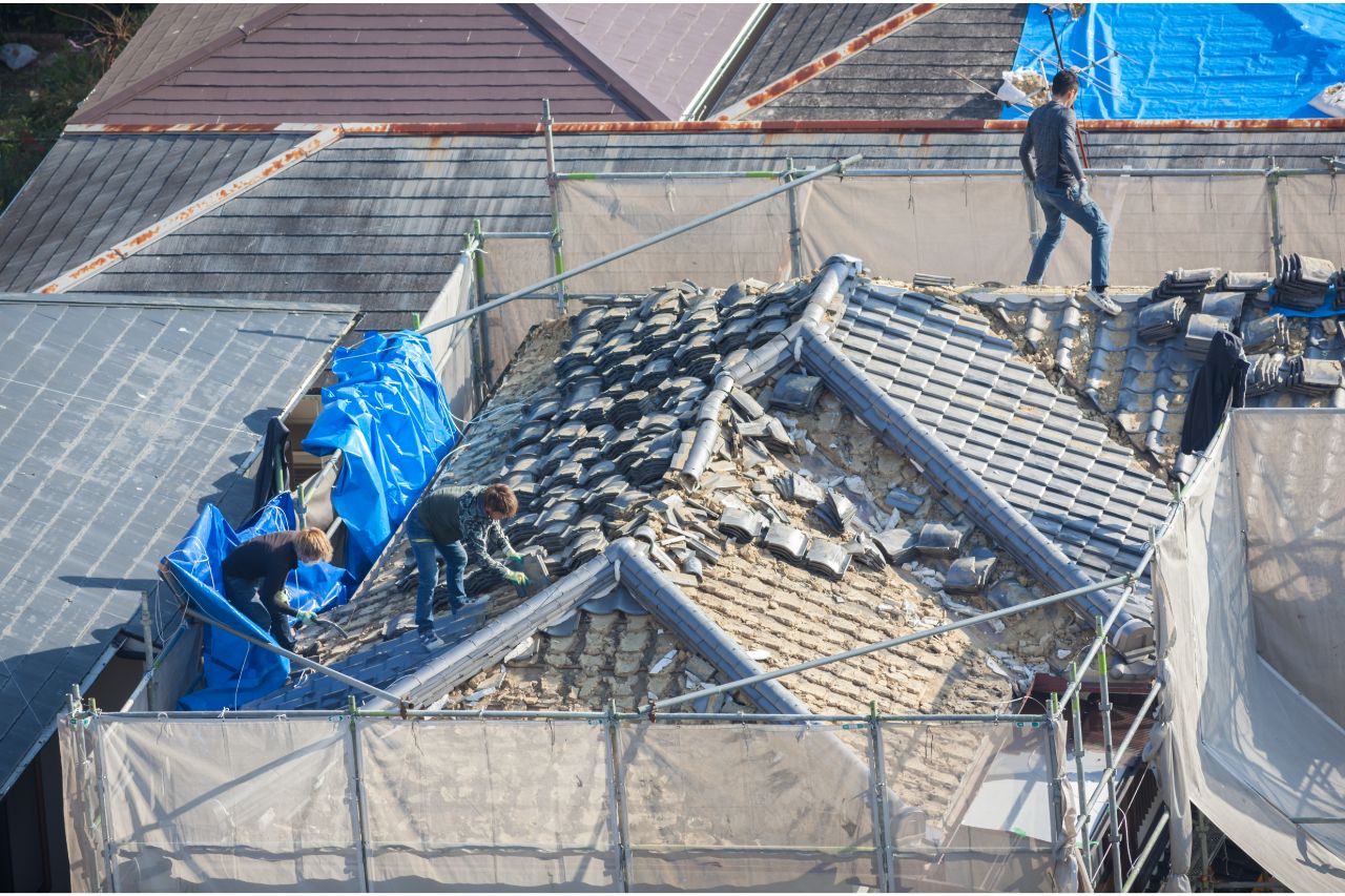 People working on a roof damaged by natural disaster
