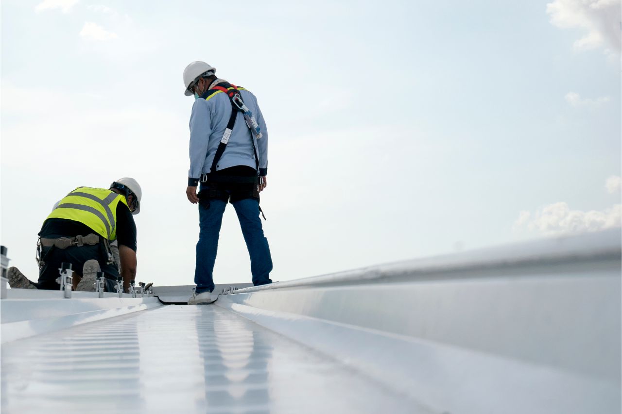 Construction workers installing a corrugated metal roof