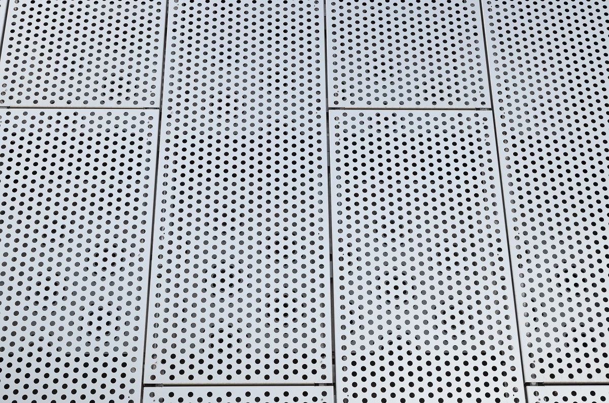 Metal grilles with many round holes in the ceiling. Dot pattern on surface.