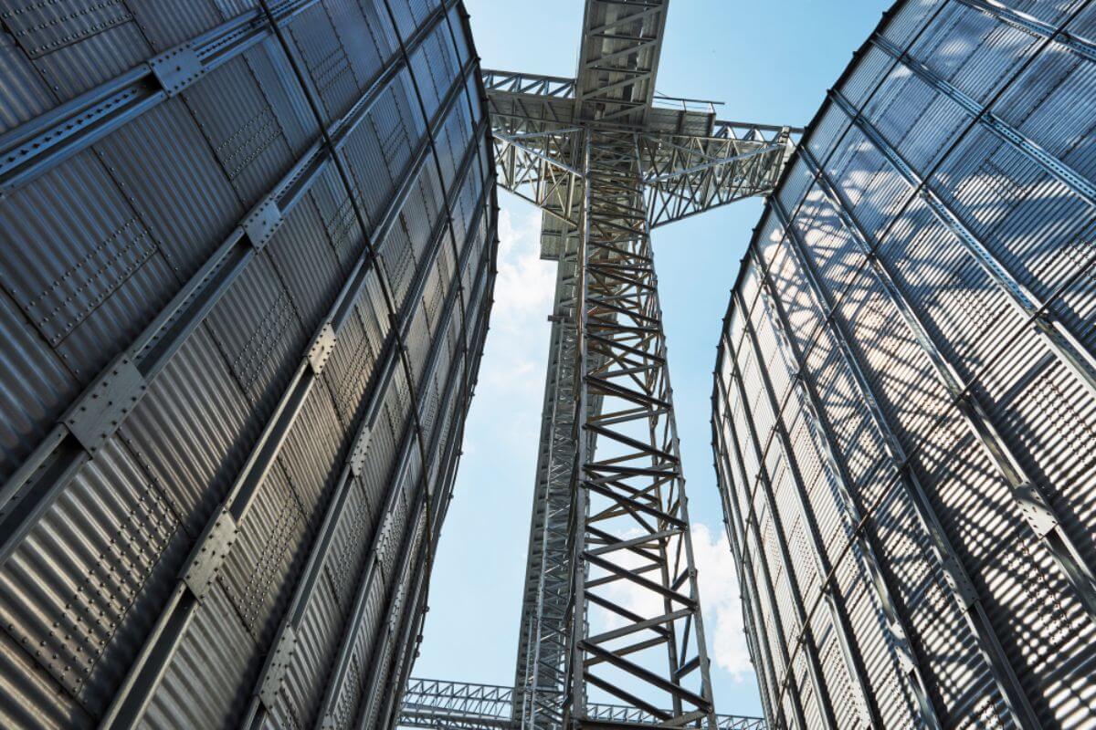 Tall industrial steel structures and framework viewed from below between metal building panels
