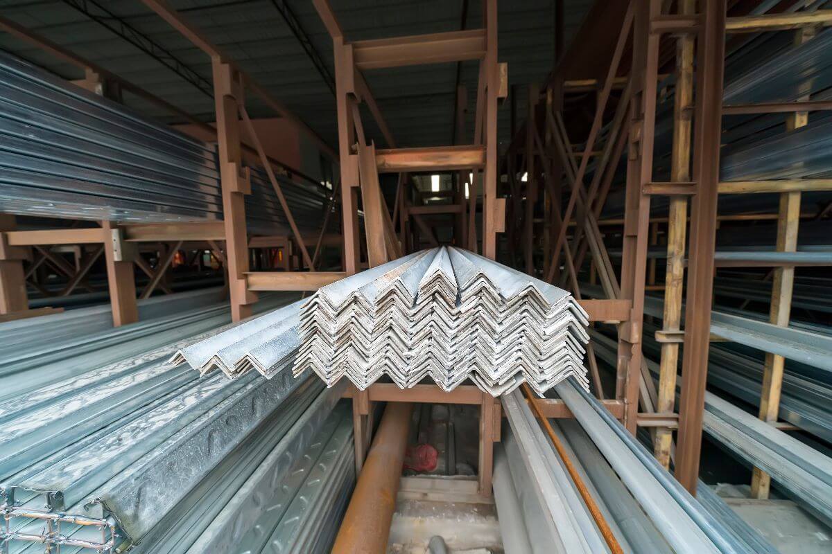 Galvanized angle bars arranged on racks inside a steel warehouse